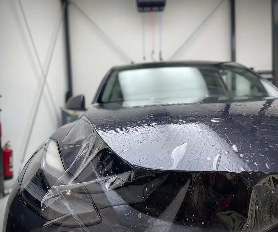 Transparent film being applied to a Tesla