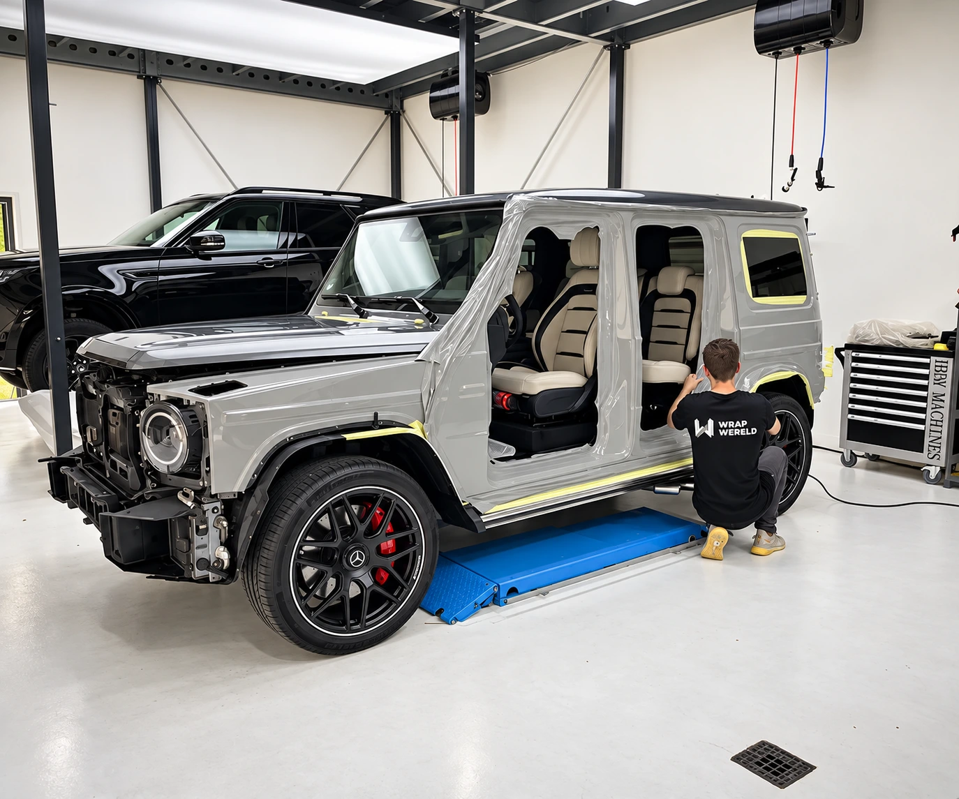 A team member applies wrap film around the door opening of a Mercedes G-Class