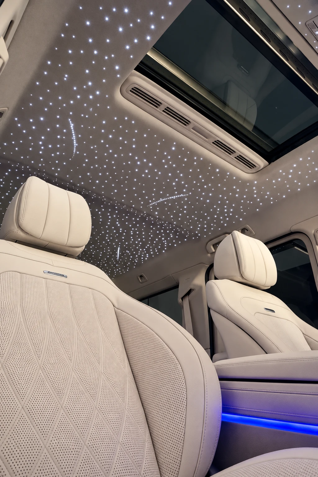 Starlight headliner with a curved star pattern above a light leather Mercedes interior